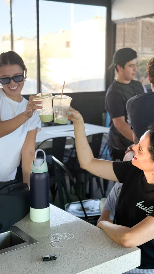 Clientas brindando con sus bebidas en la terraza de Hula